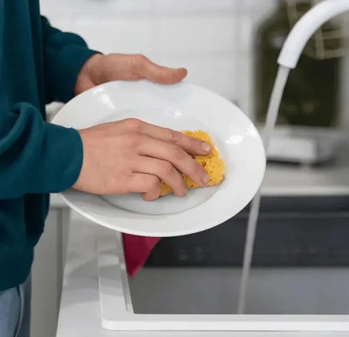 Limpiar un plato sobre un fregadero